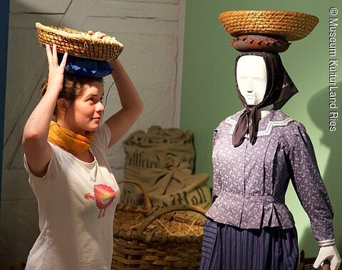 Balanceakt, Ausstellung im Museum KulturLand Ries Eine Frau führt vor, wie die Körbchen früher auf dem Kopf getragen wurden