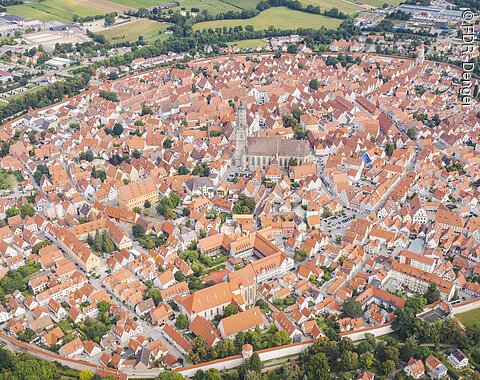 Luftaufnahme Nördlingen Luftaufnahme einer mittelalterlichen Stadt mit kreisförmiger Stadtmauer und roten Dächern.